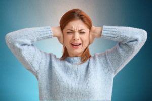 Woman with tinnitus cupping her ears
