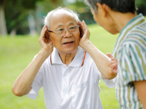 Older man with hearing loss cupping his ears