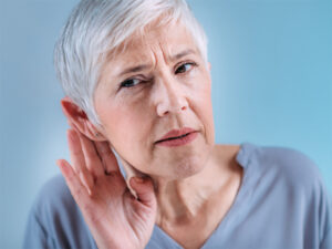 Woman with short gray hair struggles to hear 