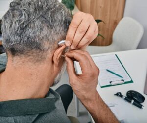 A man is wearing a hearing aid in Naples and Estero, FL